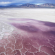 Pink water washes over a salt crust on May 4, 2021, along the receding edge of the Great Salt Lake.
